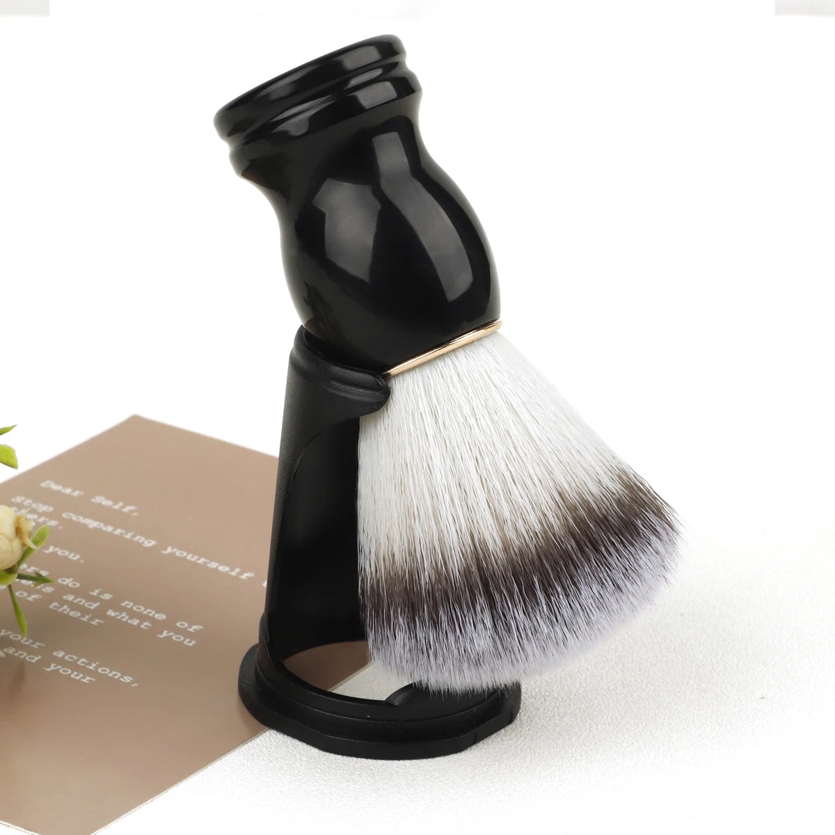 Black shaving brush with white bristles on a white background