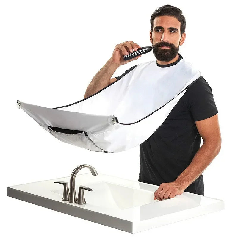Man using a hair dryer with a white bib over his clothes in a bathroom setting.