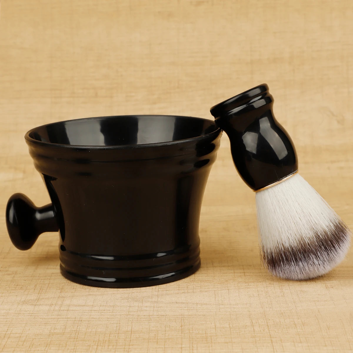 Black shaving mug and brush set on a beige woven background